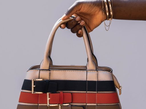 person holding black red and white plaid handbag