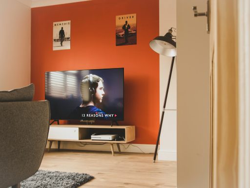 black flat screen tv turned on near white and black torchiere