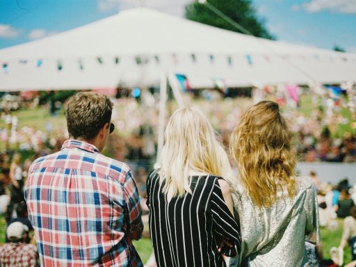 three person's standing front of field