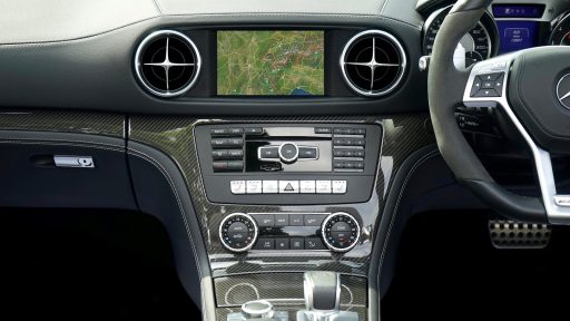 Close-up of a Mercedes Benz car dashboard featuring a navigation system and modern controls.