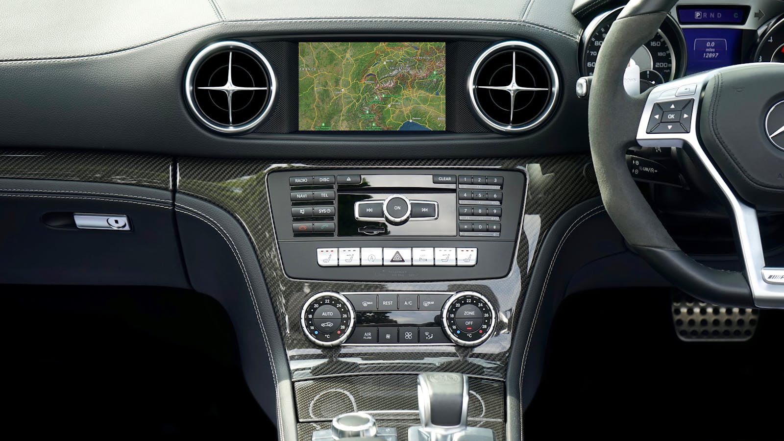 Close-up of a Mercedes Benz car dashboard featuring a navigation system and modern controls.