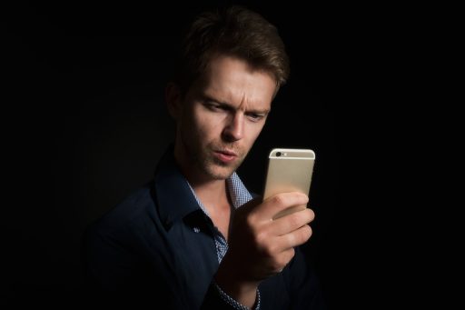 Persoon die een rekenmachine gebruikt op een smartphone aan een bureau
