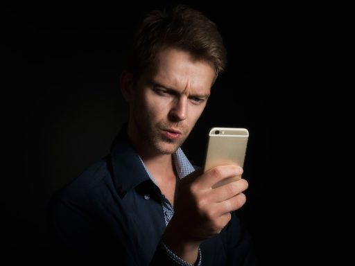 Persoon die een rekenmachine gebruikt op een smartphone aan een bureau