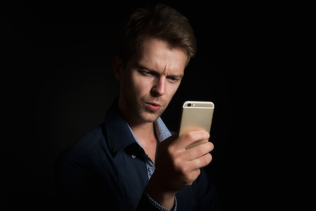 Persoon die een rekenmachine gebruikt op een smartphone aan een bureau