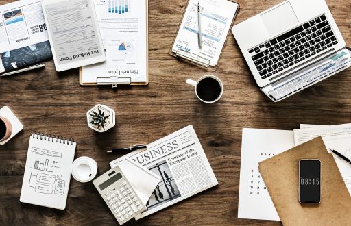 Persoon die een zomerbudget uitschrijft in een notitieboek aan een zonnige tafel