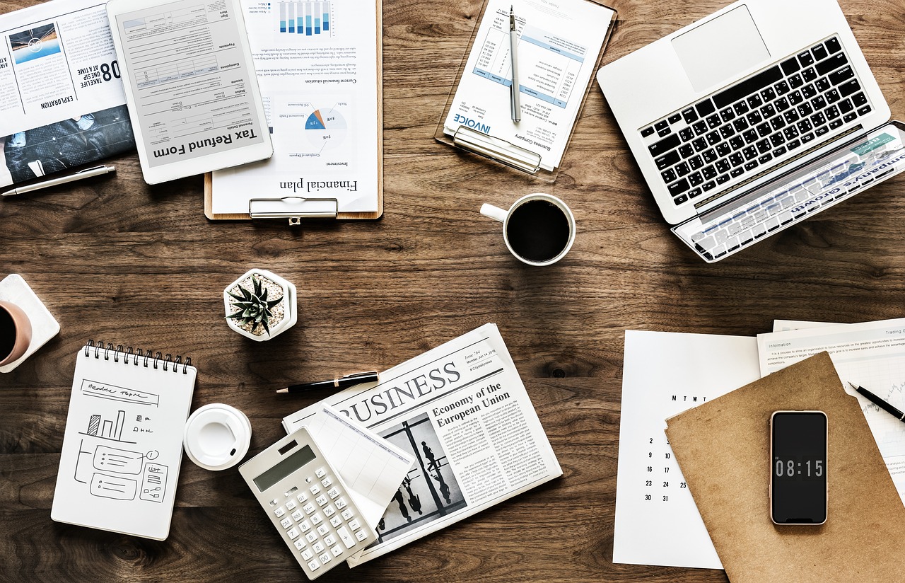 Persoon die een zomerbudget uitschrijft in een notitieboek aan een zonnige tafel