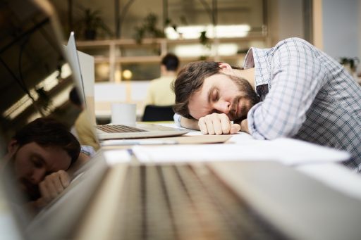 Werknemer die een korte pauze neemt aan zijn bureau en even ontspant