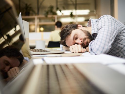 Werknemer die een korte pauze neemt aan zijn bureau en even ontspant