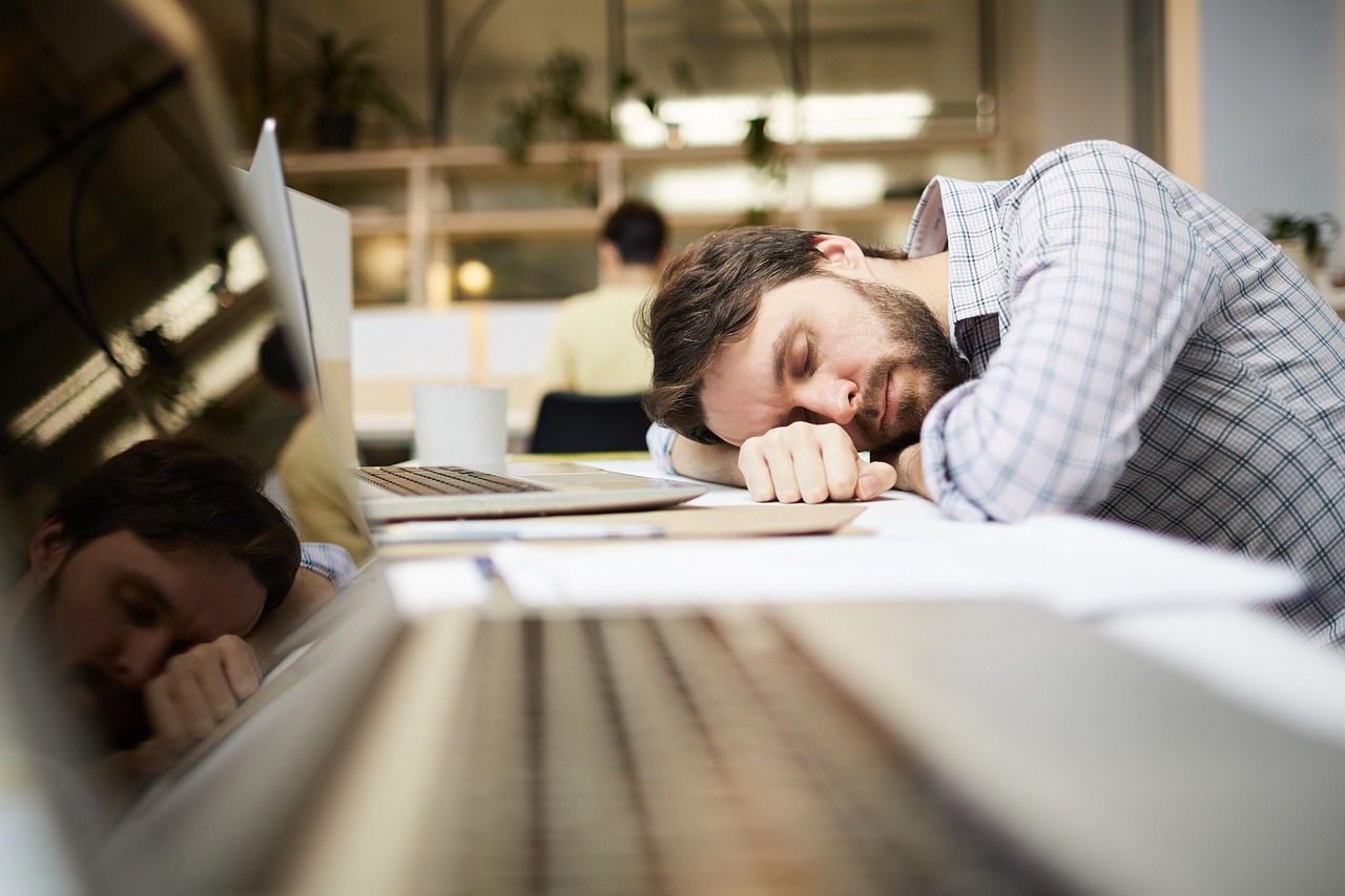 Werknemer die een korte pauze neemt aan zijn bureau en even ontspant