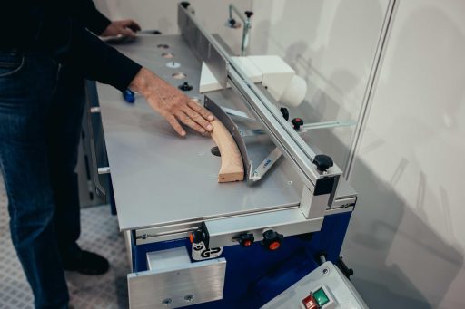 Een excentrische schuurmachine in gebruik op een houten tafelblad