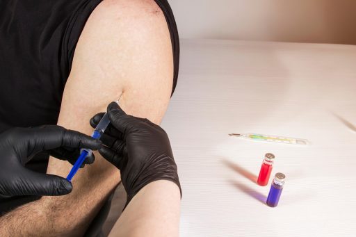 Verpleegster die een griepvaccin toedient in de arm van een volwassene