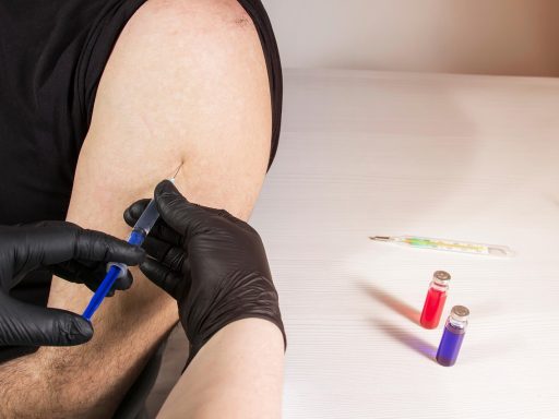 Verpleegster die een griepvaccin toedient in de arm van een volwassene